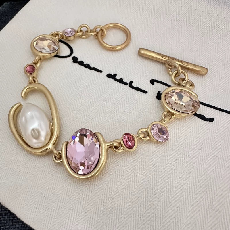 O-ring crystal pearl bracelet, gold tone with pink oval stones, pearl drop, toggle clasp