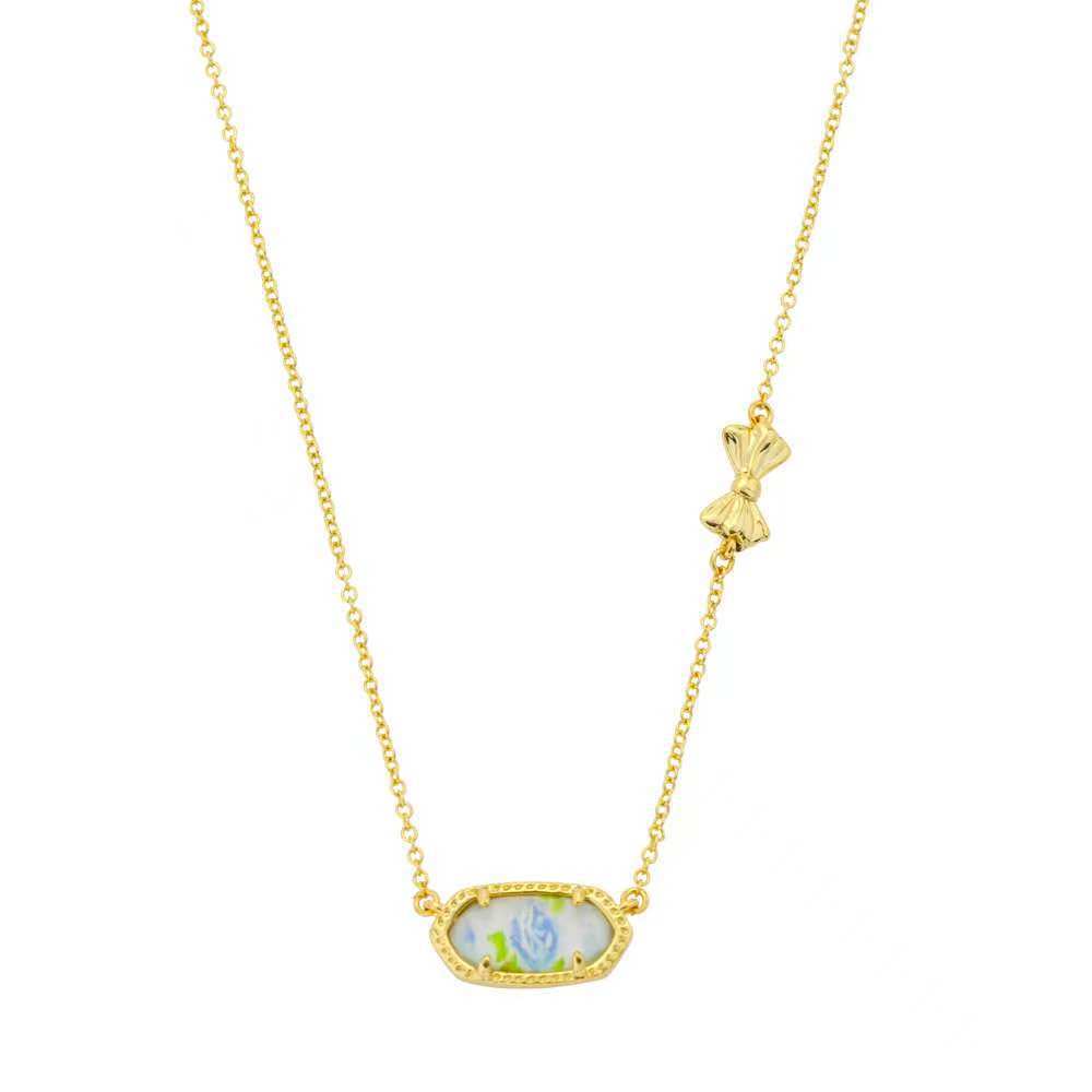 Bow rose print pendant necklace with blue oval gemstone and floral bow charm