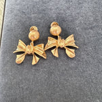 Gold-tone bow stud earrings with round backs and ribbon bow details