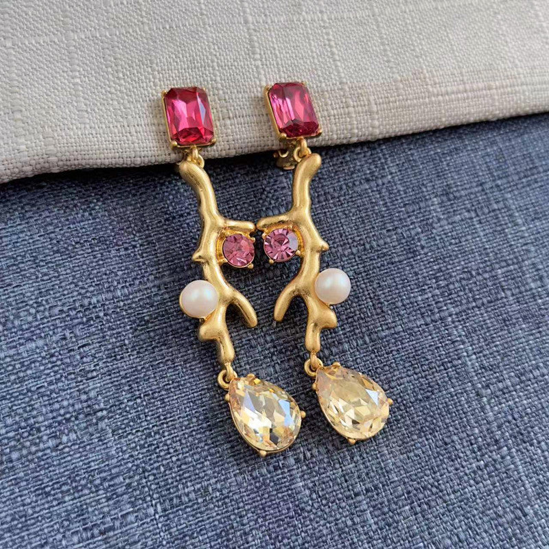 Clip-on earrings with gold branch design, pink stones, white pearls, and crystal drop charms