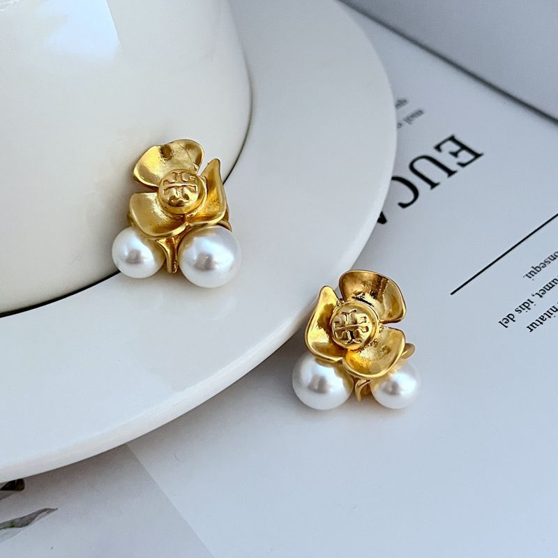 Goldfarbene Blumen-Ohrringe mit zwei weißen Perlen, seitliche Ansicht