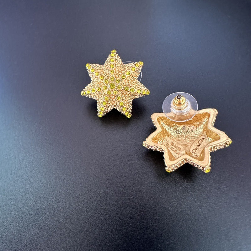 Oscar de la Renta gold star stud earrings with yellow-green stones and clasp backs
