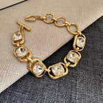 Square crystal toggle bracelet with clear/white stones and gold link settings
