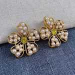 White pearl floral stud earrings with yellow round center and gold openwork frame