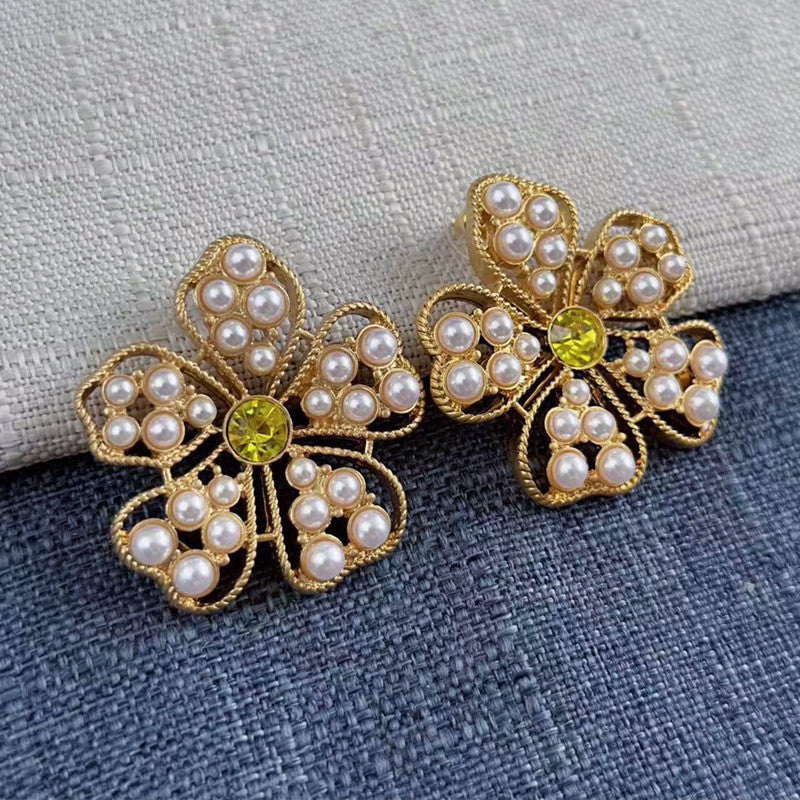 White pearl floral stud earrings with yellow round center and gold openwork frame