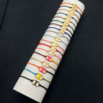 Adjustable woven drawstring bracelet set in multicolor cords with gold-tone clover charms