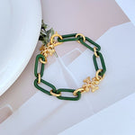 Chunky chain logo bracelet in green with gold-tone links and quatrefoil charms