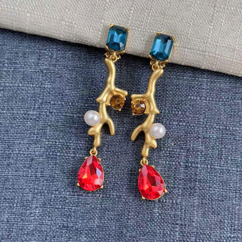 Clip-on earrings with gold branch design, blue top stones, red teardrops, and white pearls