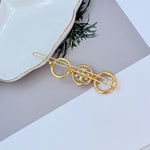 Gold-tone round diamond hair clip with bar pins and pavé center disc