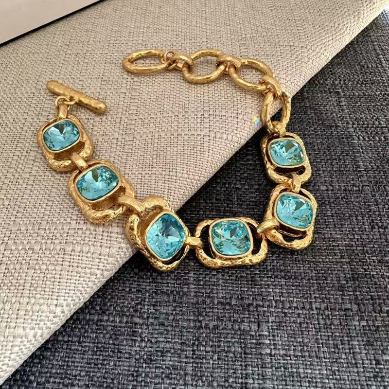 Square crystal toggle bracelet with aqua-blue stones and gold link chain
