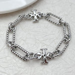 Silver square-logo chain bracelet with chunky links and stacked charm accents