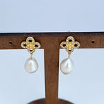 Gold four-leaf clover earrings with large white freshwater pearl dangle