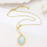 Gold-tone pendant necklace with blue floral inlay octagon pendant on chain