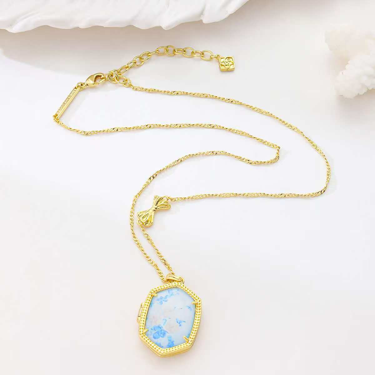Gold-tone pendant necklace with blue floral inlay octagon pendant on chain
