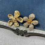 Two five-petal flower earrings in gold tone with clear rhinestone pavé petals