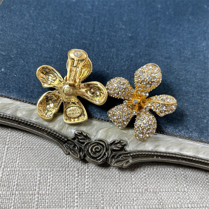Two five-petal flower earrings in gold tone with clear rhinestone pavé petals