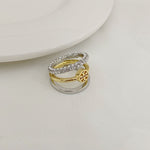 Two-tone three-band ring with silver pavé band and gold logo medallion