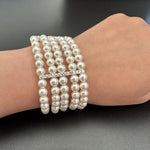Multi-row pearl rhinestone stretch bracelet on wrist, silver-toned stone clasp