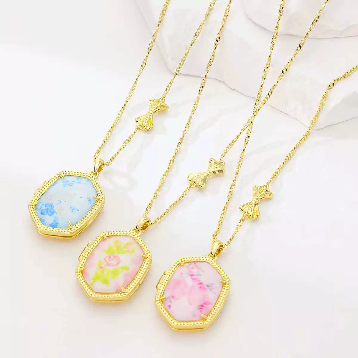 Gold-tone pendant necklace set: blue and two pink floral inlay pendants