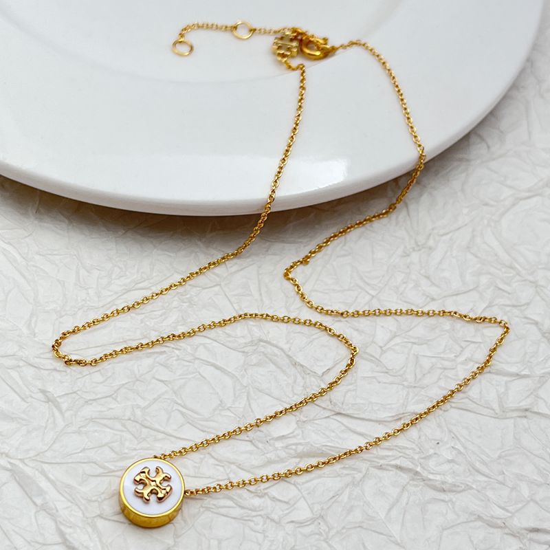 Gold necklace with round enamel pendant, white face and gold logo charm