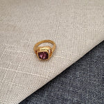 Square ring with purple gemstone in textured gold band and open setting
