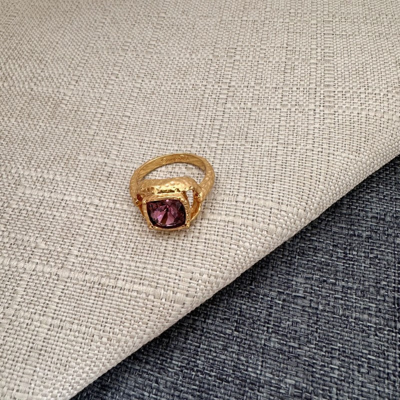Square ring with purple gemstone in textured gold band and open setting