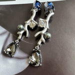Clip-on earrings with silver-tone branch design, blue stones, clear drops, and gray pearls