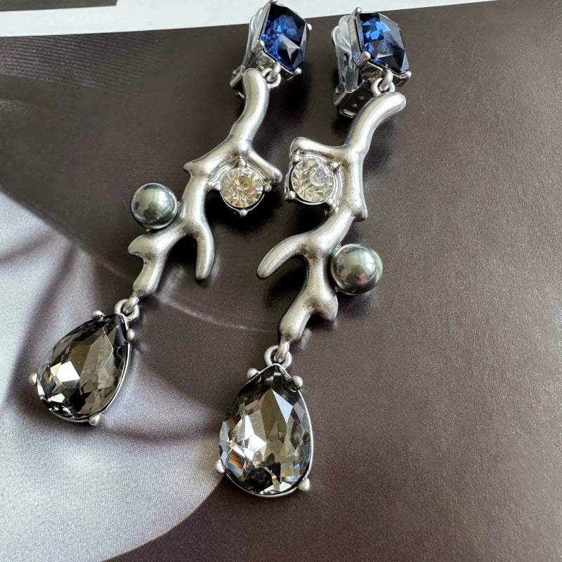 Clip-on earrings with silver-tone branch design, blue stones, clear drops, and gray pearls