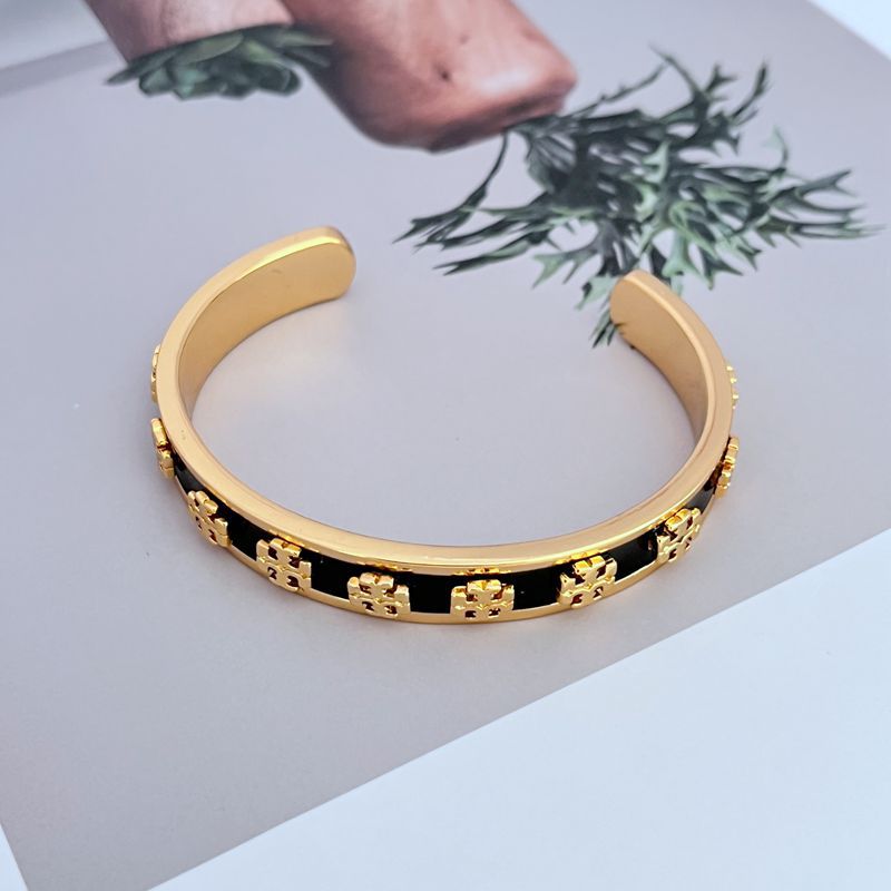 Offener Armreif mit schwarzem Emailband und goldfarbenen Logo-Elementen