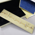 Gold tone bracelet with white clover charms on a fine chain