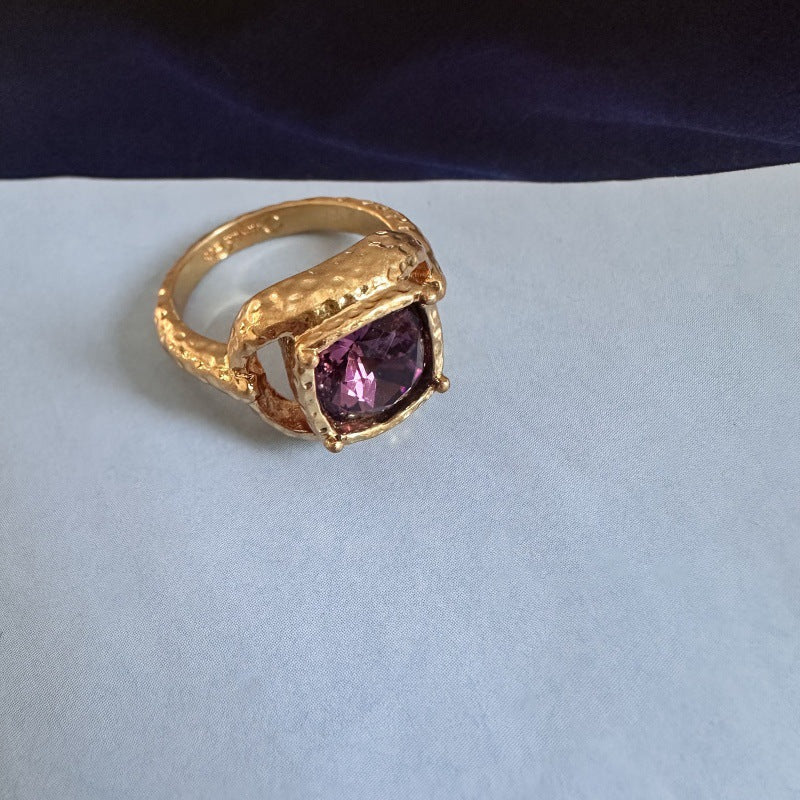 Square ring with purple gemstone set in textured gold and openwork band