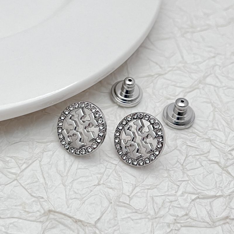 Round logo stud earrings in white-gold tone, rhinestone border and openwork emblem