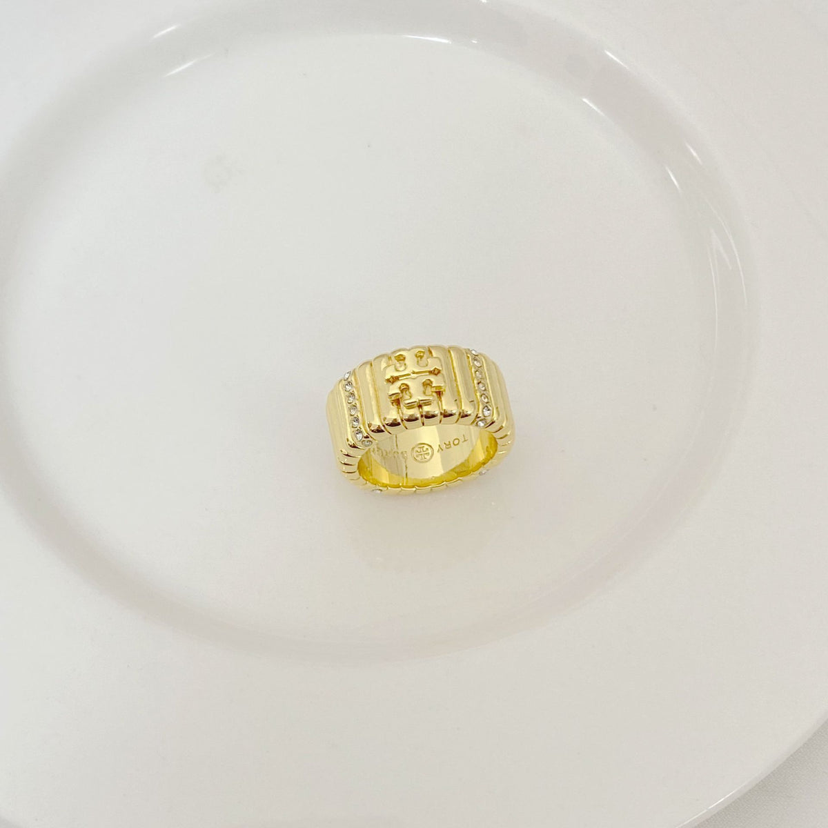 Gold-tone rhinestone letter inlay ring with engraved front panel and logo detail