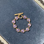 Purple crystal heart link bracelet with gold-tone chain and heart-shaped stones