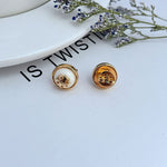 Round logo resin stud earrings, white resin center with gold-tone bezel