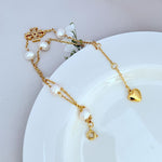 Gold bracelet with freshwater pearl drops, heart charm, and circular clasp ring