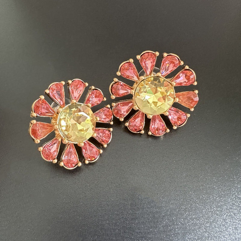 Sunburst flower stud earrings with pink teardrop stones, yellow center, gold-tone setting