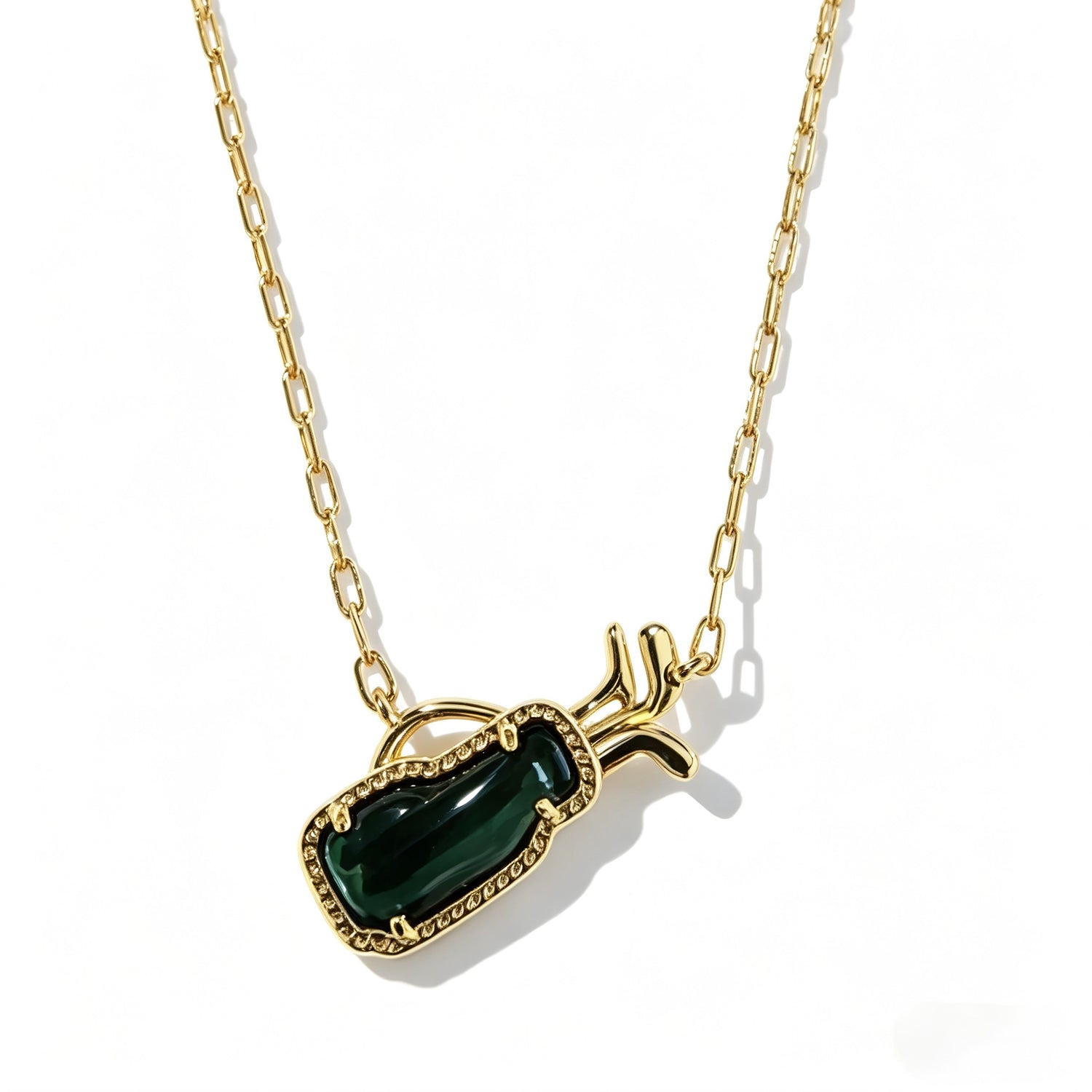 Gold-tone necklace close-up with green gem-like rectangular pendant and side horn accents