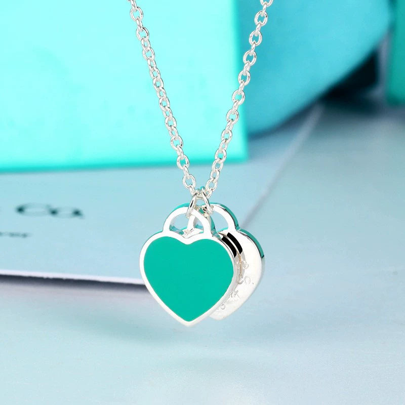 Enamel double heart pendant necklace with teal heart charm and silver-tone links