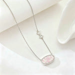 Silver-tone bow charm oval pendant necklace with pink floral enamel