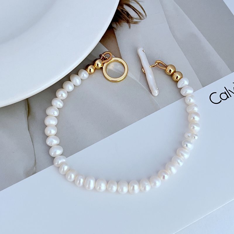Pearl bracelet with gold-tone ring clasp and bead-and-chain links