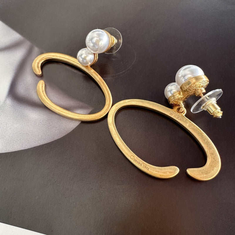 O-ring pearl earrings with gold-tone hoops, two white pearls, butterfly backs