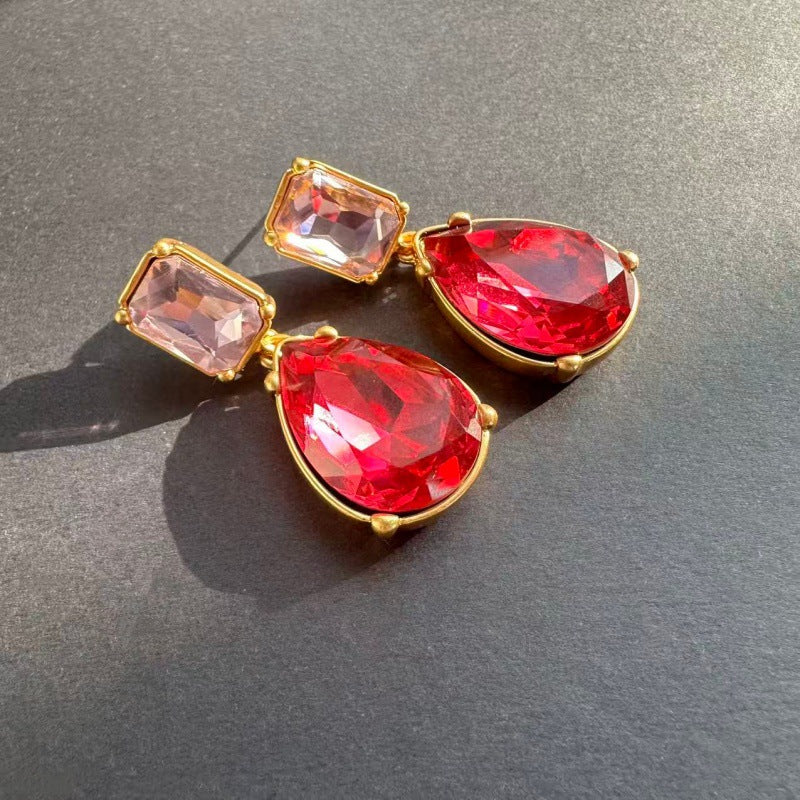 Teardrop-cut crystal stud earrings with red teardrop drops and red square tops, gold tone