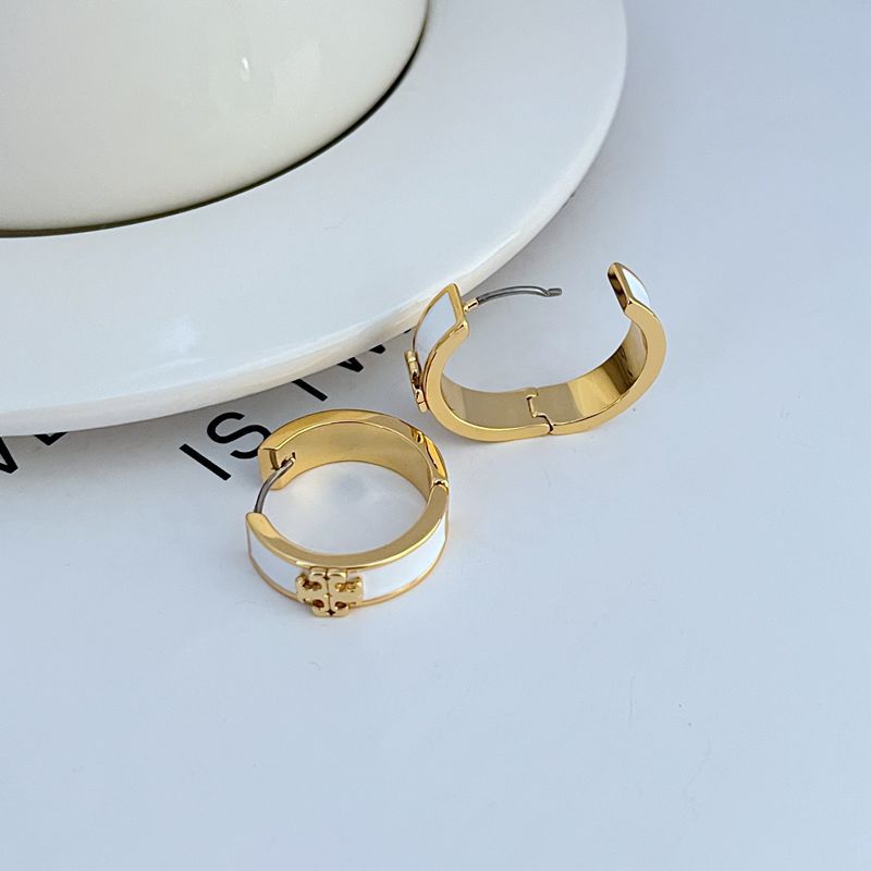 Gold-tone enamel hoop earrings with white band and visible hinge clasp