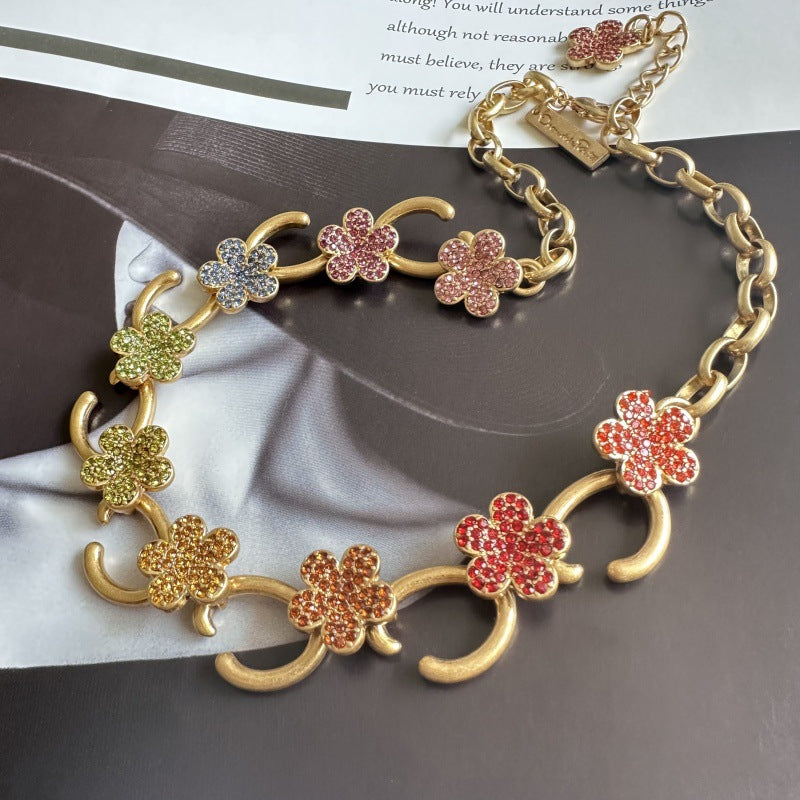 Gold-tone floral O-ring necklace with pink and red crystal flower charms