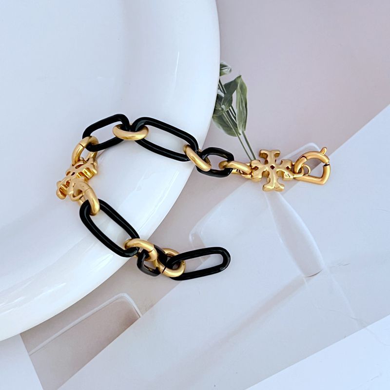 Black chunky chain logo bracelet with gold-tone links and quatrefoil charms