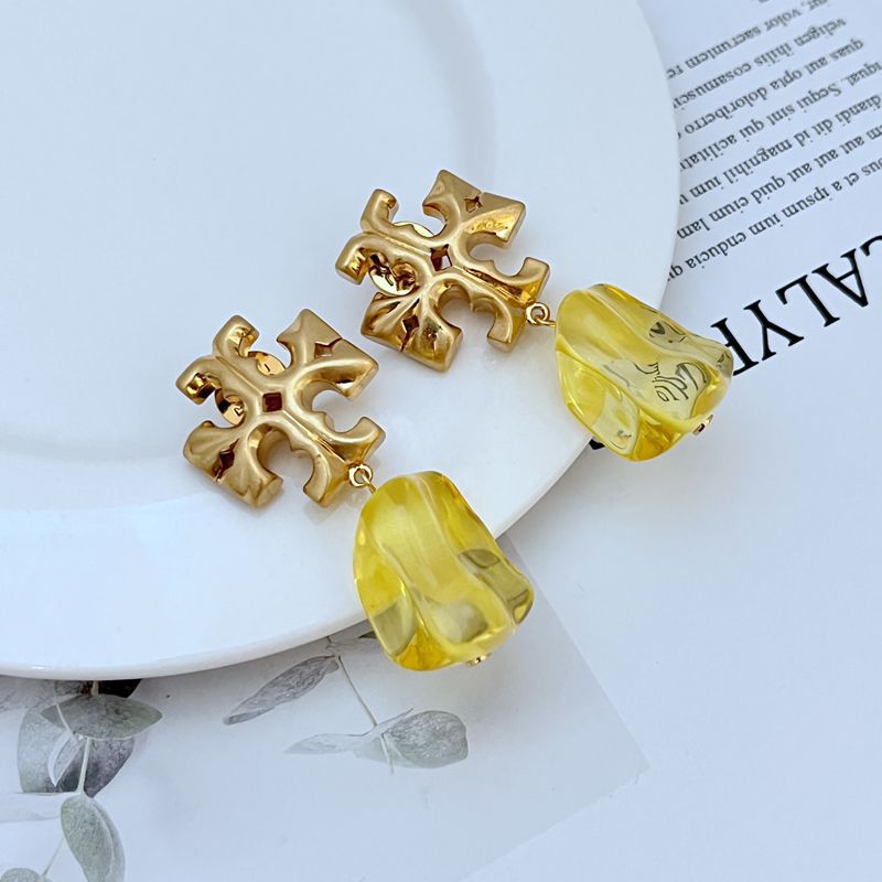 Yellow irregular acrylic logo pendant earrings with gold-tone geometric cross and curved drop