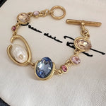 O-ring crystal pearl bracelet, gold tone with blue oval center stone, pink accents, pearl