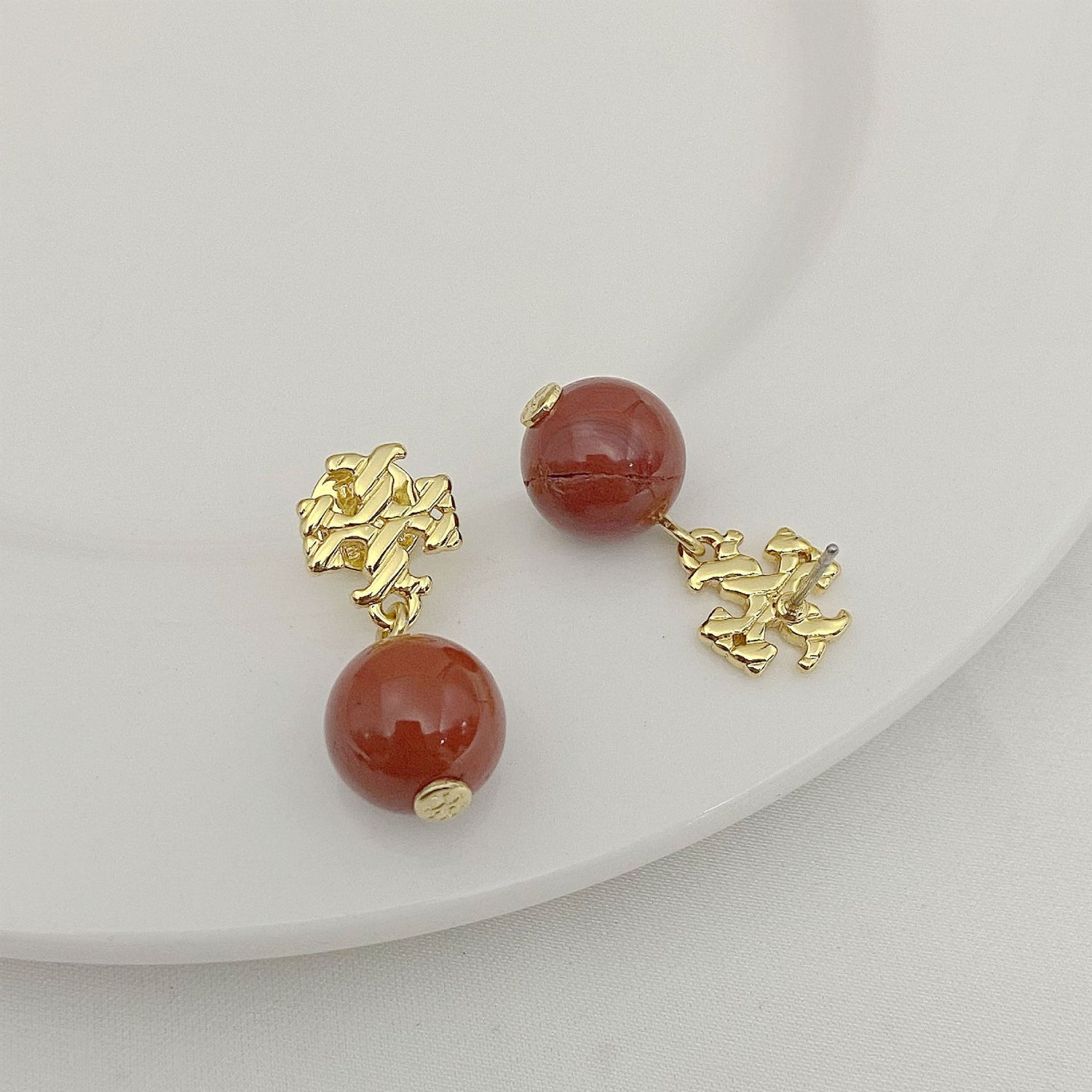 Round red agate pendant earrings with gold-tone geometric drop details
