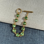 Green crystal heart link bracelet with gold-tone chain and heart-shaped stones
